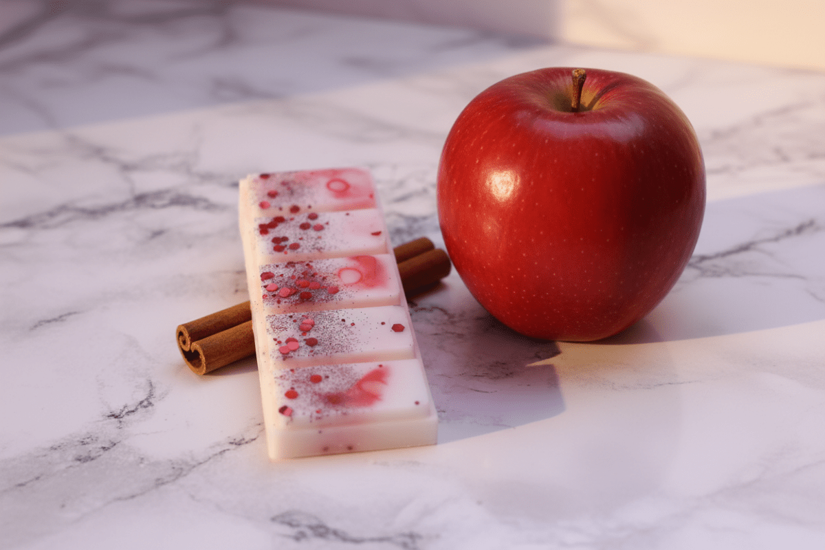 Snapbar apoyada en rama de canela con una manzana